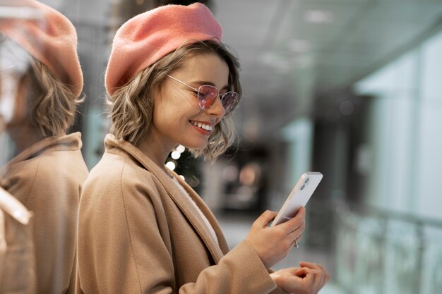 Mujer sonriente de tiro medio sosteniendo teléfono