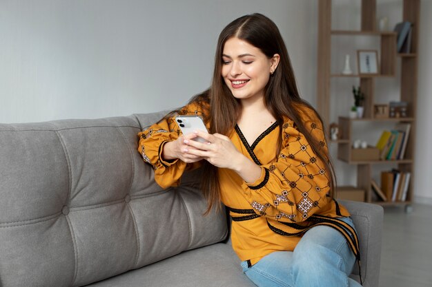 Mujer sonriente de tiro medio sosteniendo teléfono