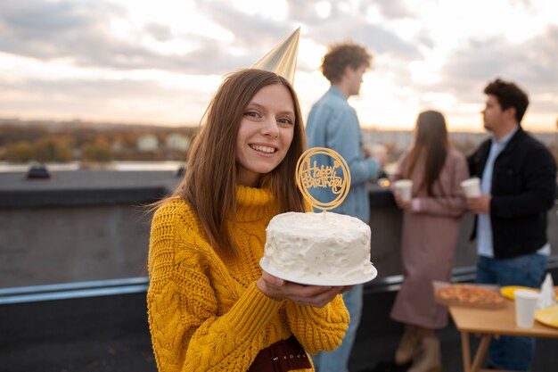 Foto gratuita mujer sonriente de tiro medio sosteniendo la torta