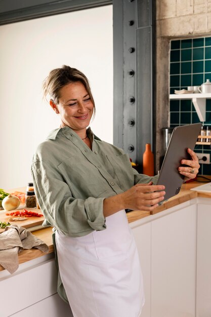 Mujer sonriente de tiro medio con tableta