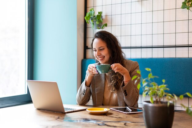 Mujer sonriente de tiro medio con tableta