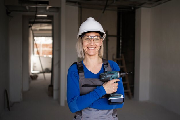 Mujer sonriente de tiro medio con taladro