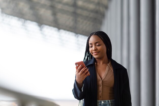 Mujer sonriente de tiro medio con teléfono inteligente