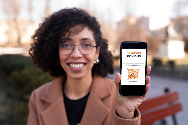 Mujer sonriente de tiro medio con teléfono inteligente