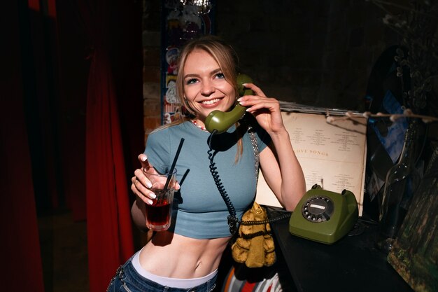 Mujer sonriente de tiro medio con teléfono vintage