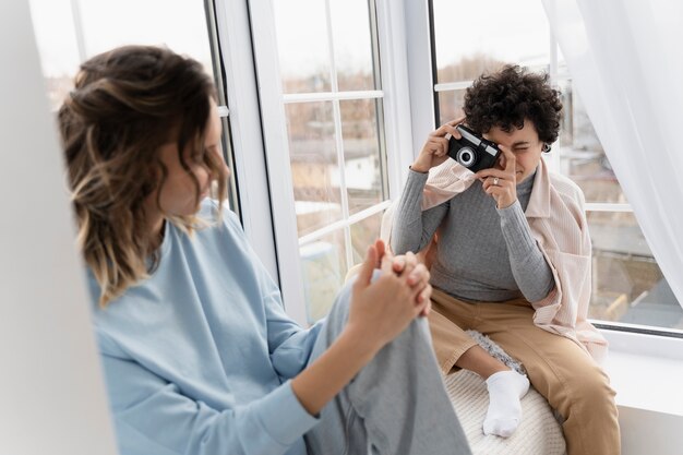 Mujer sonriente de tiro medio tomando fotos