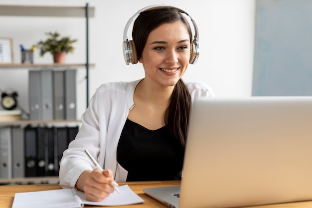 Mujer sonriente de tiro medio tomando notas