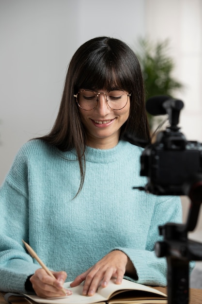 Mujer sonriente de tiro medio tomando notas