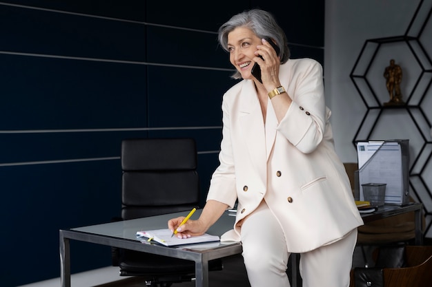 Mujer sonriente de tiro medio tomando notas