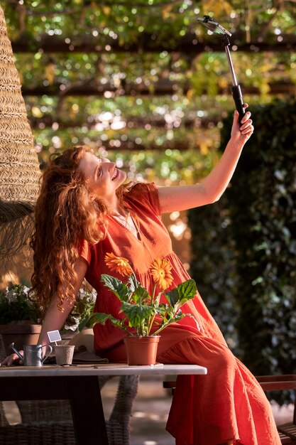 Mujer sonriente de tiro medio tomando selfie