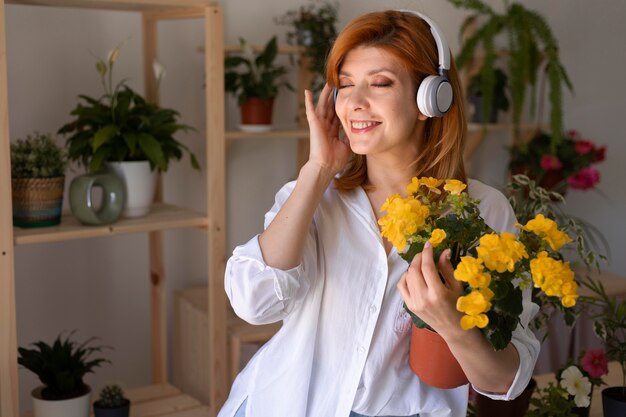 Mujer sonriente de tiro medio usando audífonos