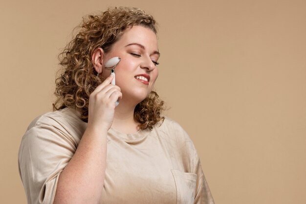 Mujer sonriente de tiro medio usando gua sha