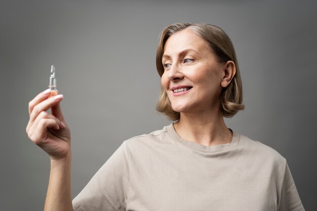 Mujer sonriente de tiro medio con vial