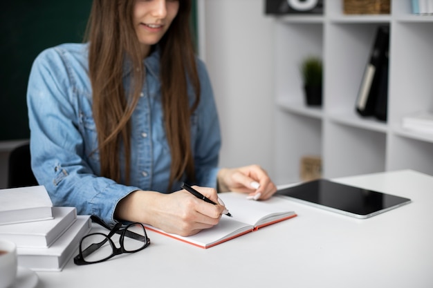 Mujer sonriente tomando notas en el interior