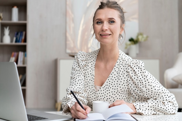 Mujer sonriente tomando notas