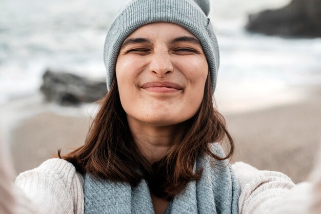 Mujer sonriente tomando un selfie en la playa.