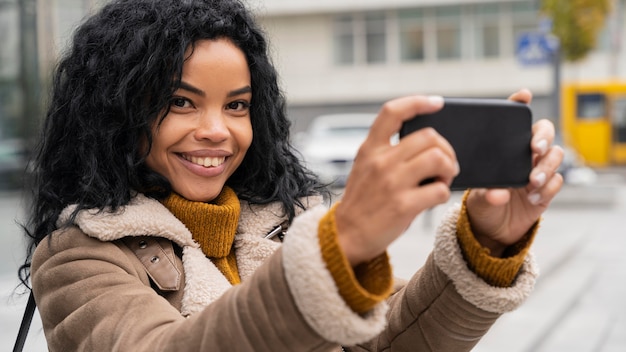 Mujer sonriente tomando un selfie con su smartphone