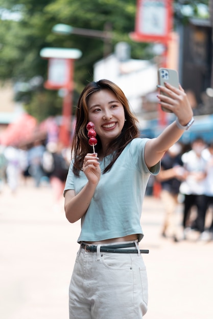 Mujer sonriente tomando selfie tiro medio