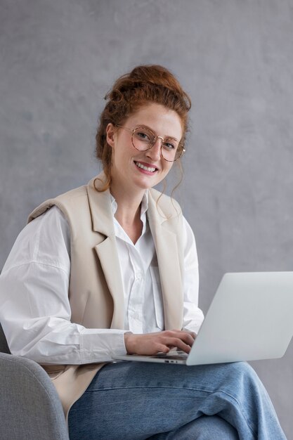 Mujer sonriente trabajando en una computadora portátil de tiro medio