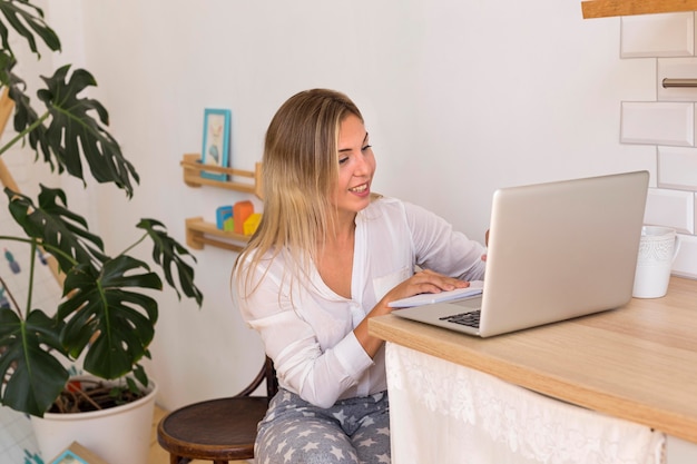 Foto gratuita mujer sonriente trabajando en equipo portátil