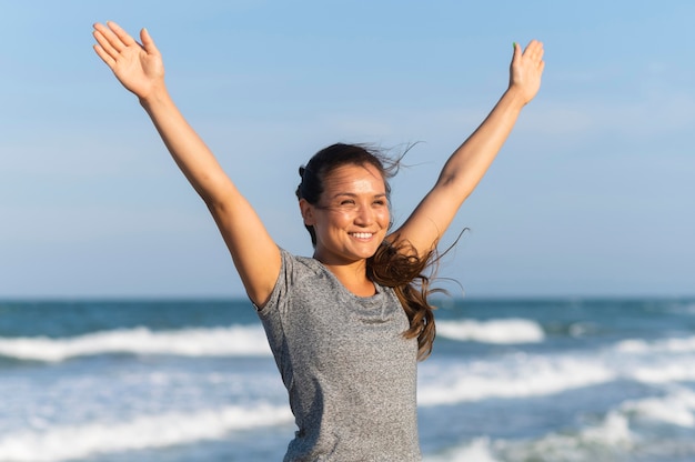 Foto gratuita mujer sonriente trabajando en la playa