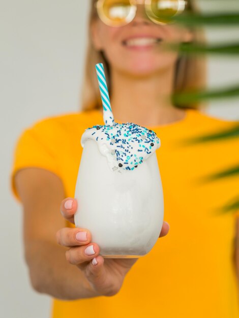 Mujer sonriente con vaso de batido