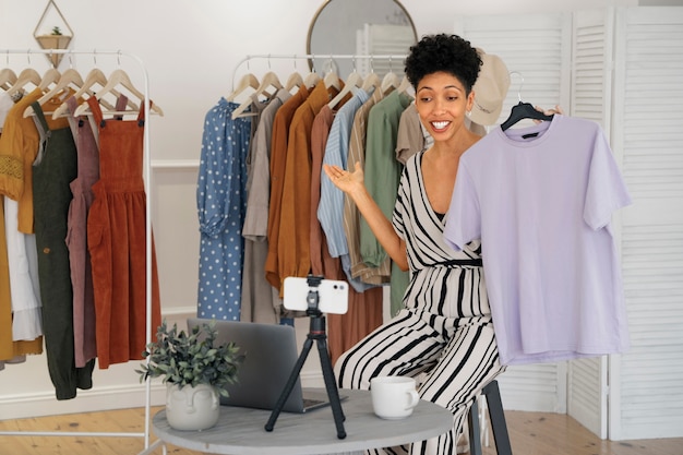 Foto gratuita mujer sonriente vendiendo ropa vista frontal