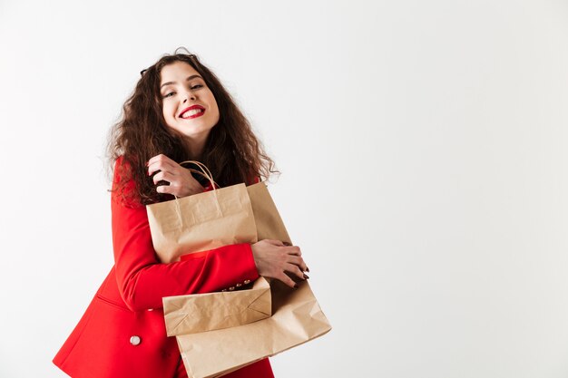 Mujer sonriente de la venta que sostiene bolsos de compras