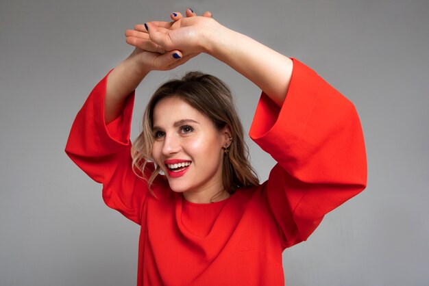 Foto gratuita mujer sonriente con vestido rojo tiro medio