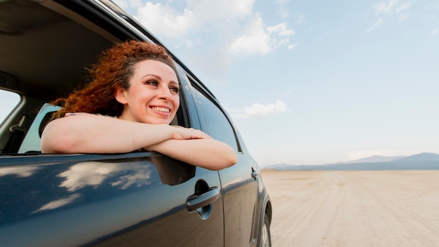 Mujer sonriente viajando con coche