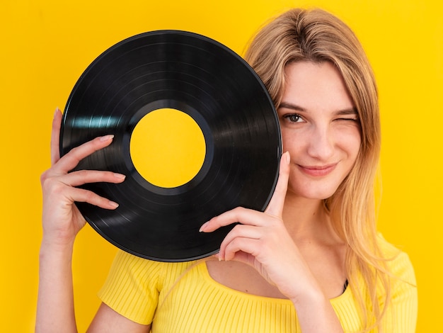 Foto gratuita mujer sonriente con vinilo