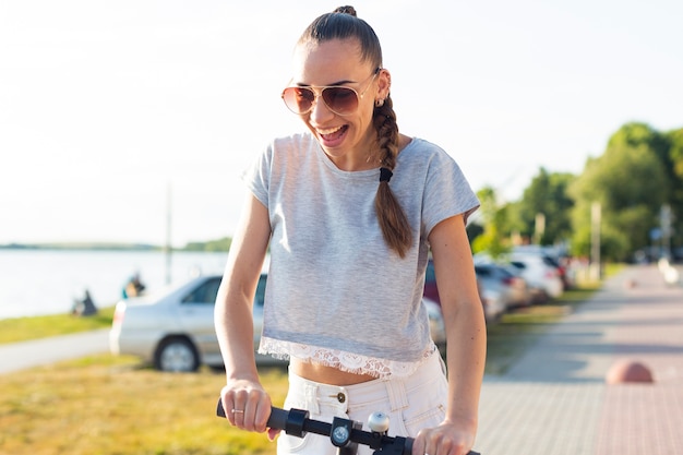 Mujer sonriente de la vista delantera en la vespa