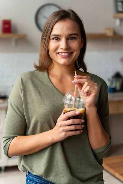 Foto gratuita mujer sonriente con vista frontal de kombucha