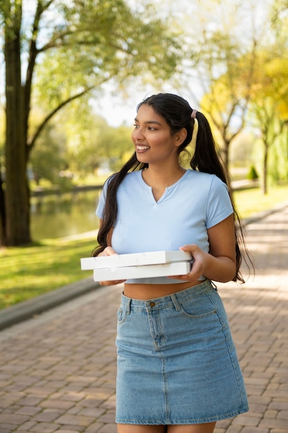 Mujer sonriente con vista frontal de pizza