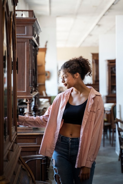 Mujer sonriente en la vista frontal de la tienda de segunda mano