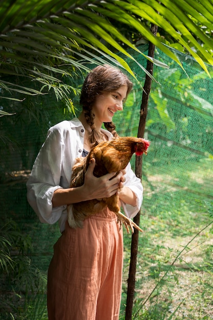 Mujer sonriente con vista lateral de gallina