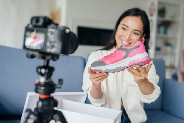 Mujer sonriente vlogging con sus zapatos deportivos