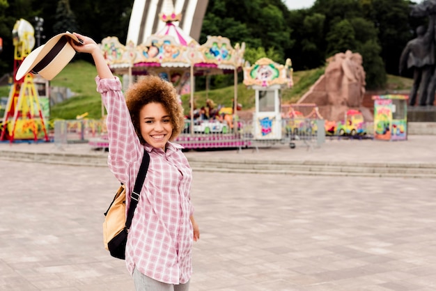 Mujer sonriente yendo a un parque de atracciones