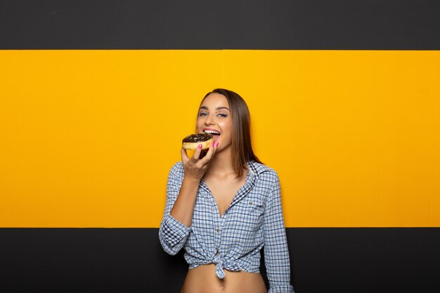 Mujer con sonrisa blanca brillante comer sabroso donut.