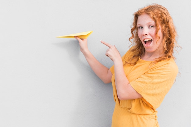 Mujer sorprendida y avión de papel