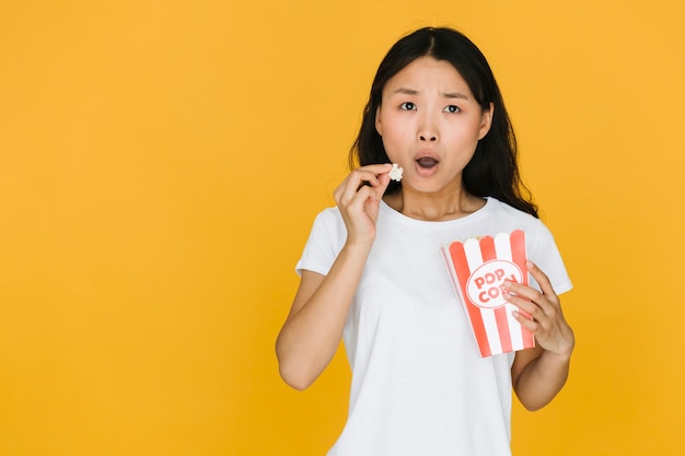 Mujer sorprendida comiendo unas palomitas de maíz