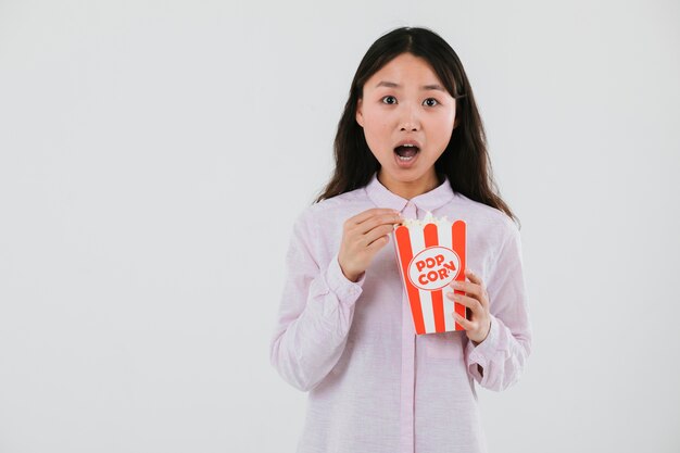 Mujer sorprendida comiendo palomitas de maíz