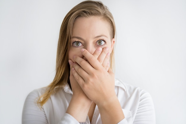 Mujer sorprendida cubriendo la boca con ambas manos