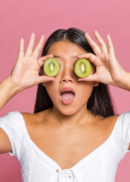 Mujer sorprendida cubriendo sus ojos con kiwi