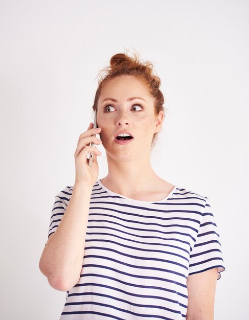 Mujer sorprendida hablando por teléfono móvil shot
