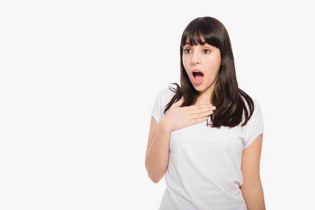 Mujer sorprendida manteniendo la mano en el pecho