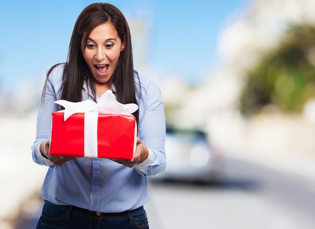 Mujer sorprendida mirando un regalo