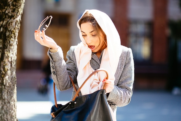 Mujer sorprendida mirando su bolso