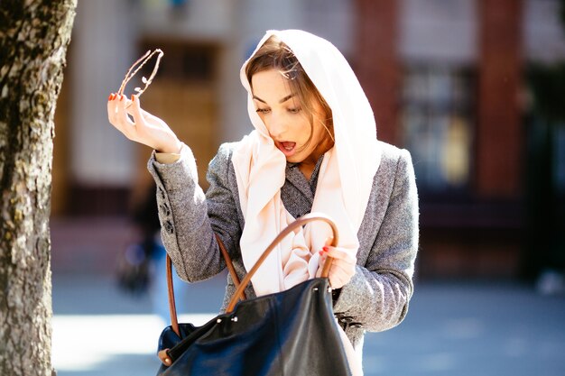 Mujer sorprendida mirando su bolso