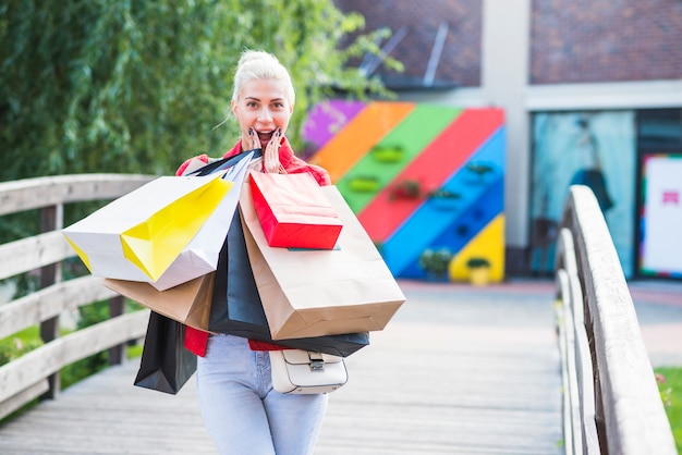 Mujer sorprendida con paquetes de compras.